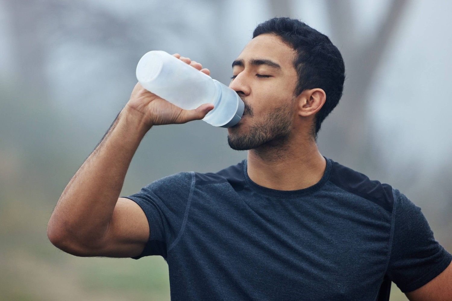 A Man Drinking Water After Jogging And Exercising